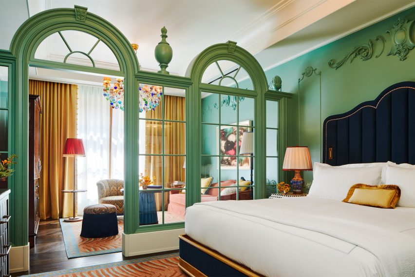 Green classical screen separates bedroom spaces