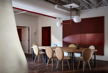 Dining table with eight round-backed chairs, and a light fixture above