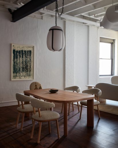 Wooden dining table with glass light above