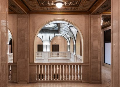 View through an arch in a stone wall of an atrium