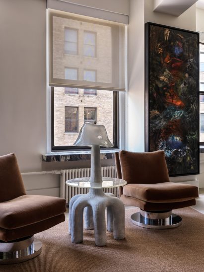 A pair of swiveling Milo Boughman chairs with a sculptural side table