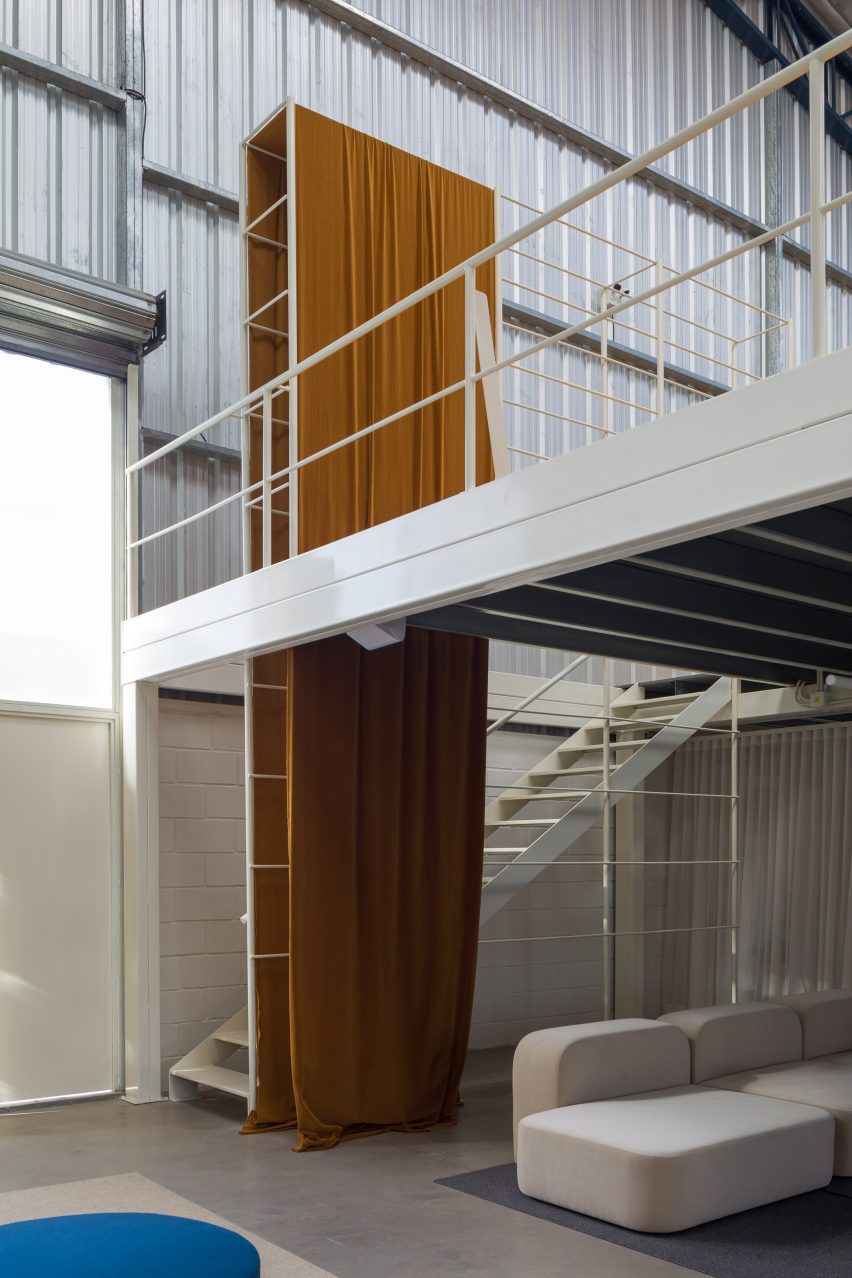a mustard tapesstry hanging from staircase