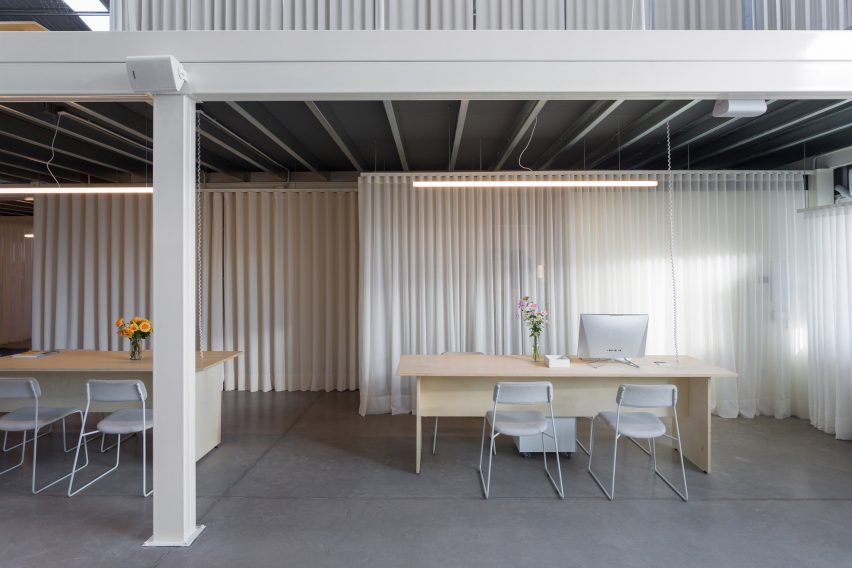 a desk in front of white curtains