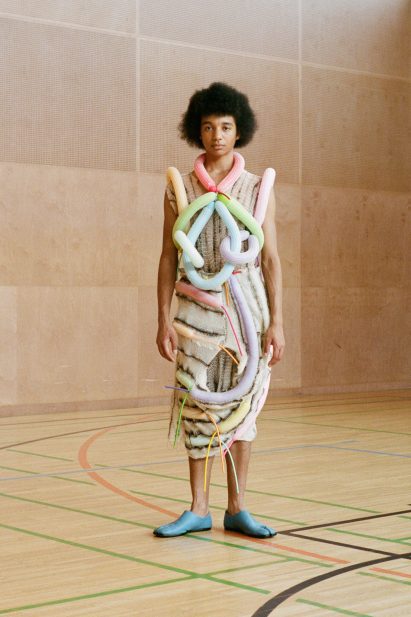Standing model wears garments with tubular balloons attached to it