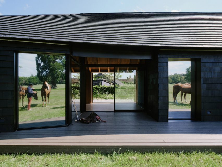 Timber-clad clubhouse in a polo field by DROO