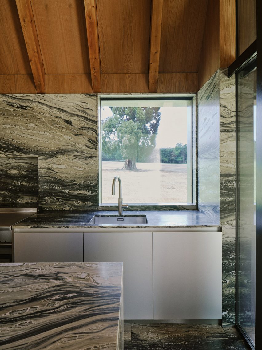 Kitchen with marble walls and timber ceiling