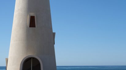 White lighthouse overlooking sea in Mexico by Gonzalo Lebrija