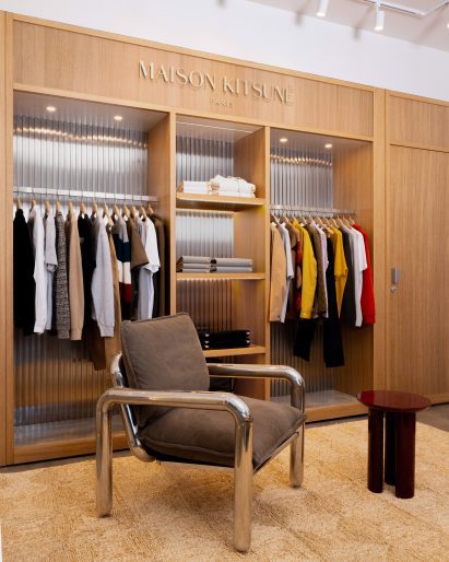 White oak built-in shelving display for clothing, with bent metal chair in front