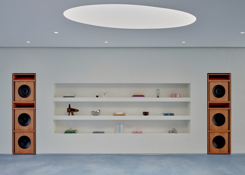 built in shelves with small objects and surrounding speakers