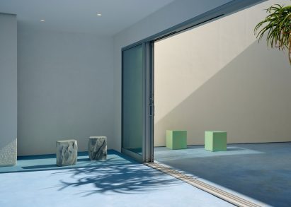 a courtyard with large sliding glass doors and various stools