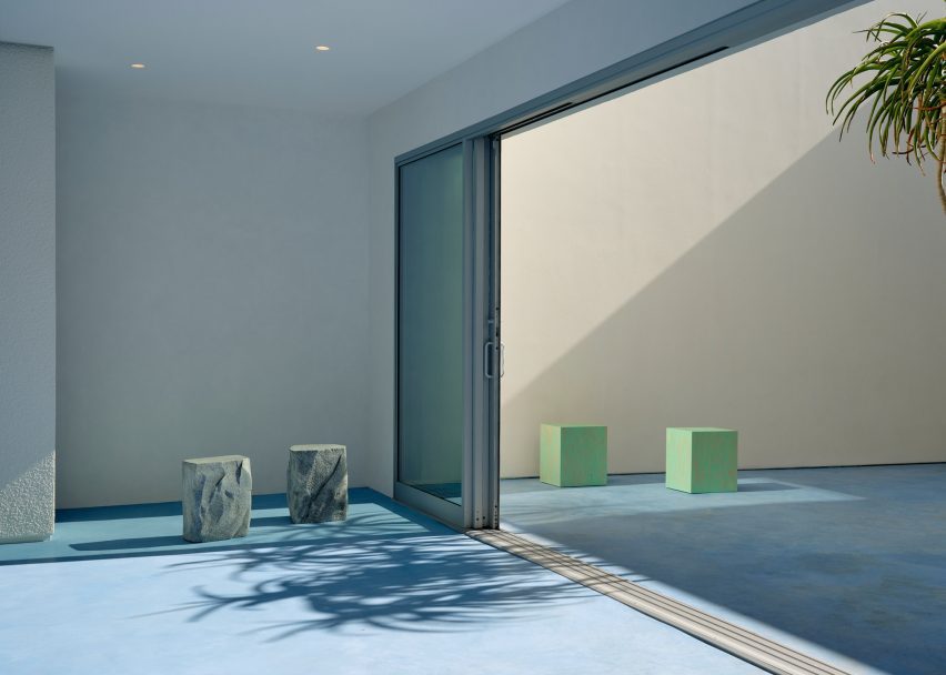 a courtyard with large sliding glass doors and various stools