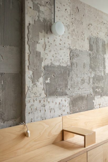 Wooden bench in front of textured concrete walls