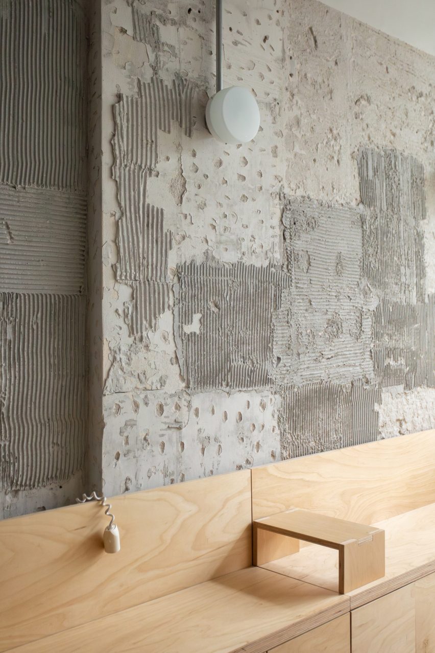 Wooden bench in front of textured concrete walls