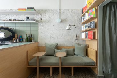 A wooden bench covered with seafoam green cushions