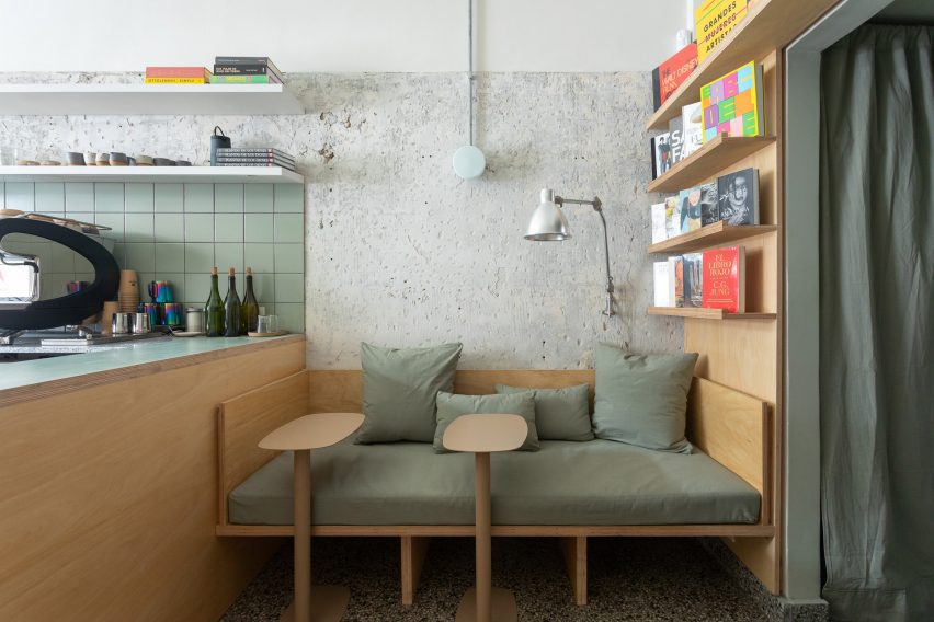A wooden bench covered with seafoam green cushions