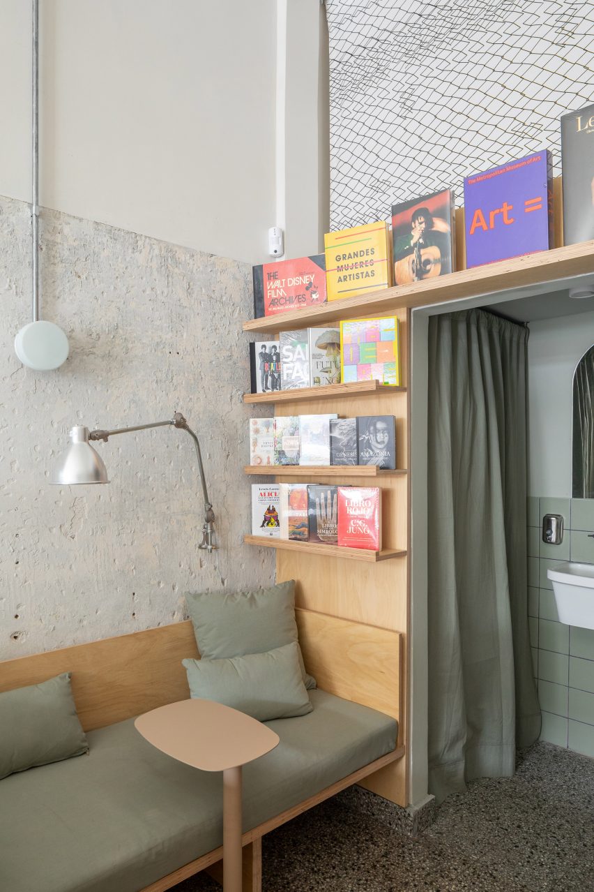 A corner with a couch, bookshelves and curtain