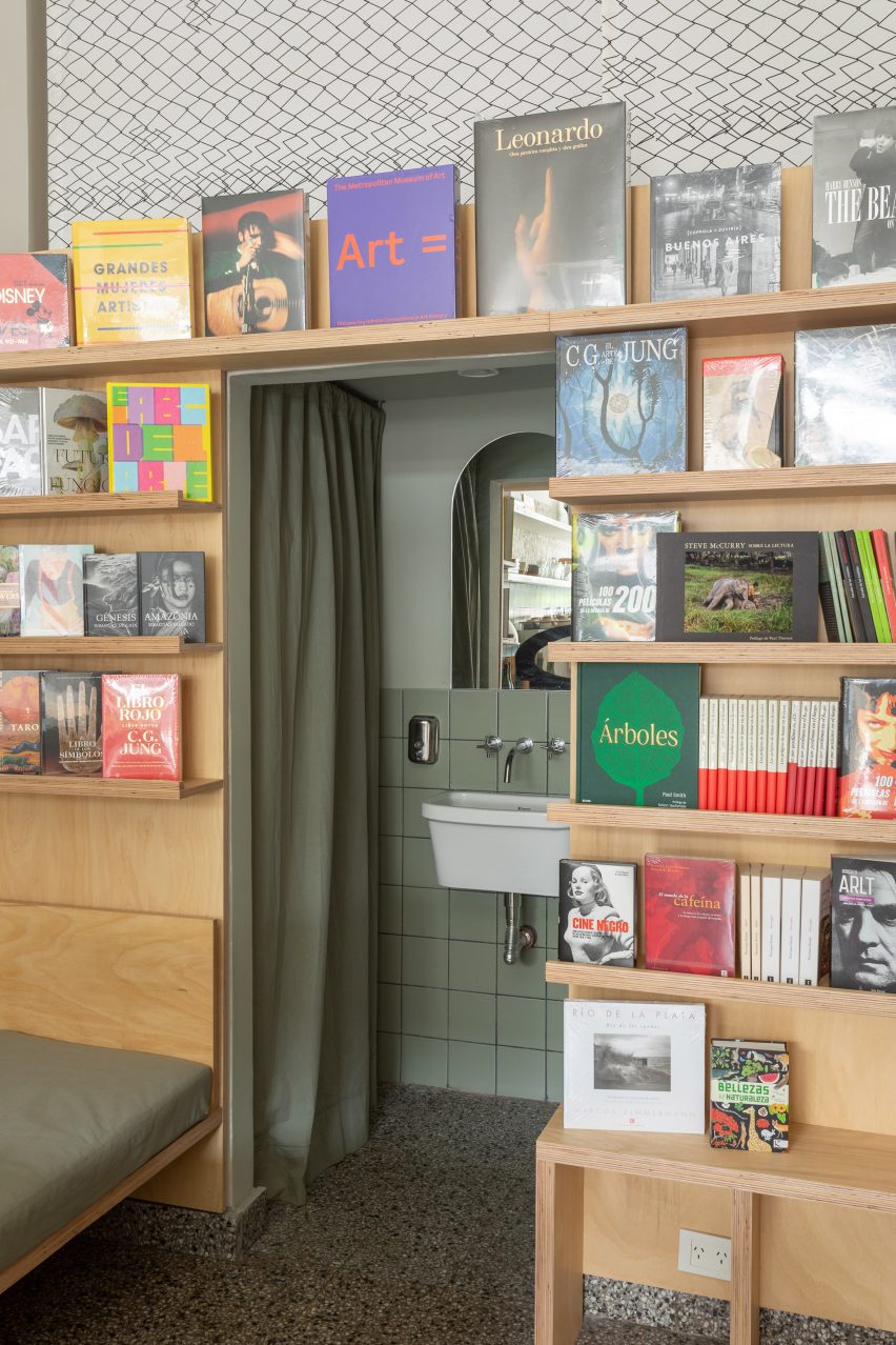 Bookshelves with a sink in the middle and a green curtain