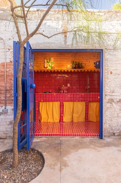 A blue door open to red-tiled kitchen