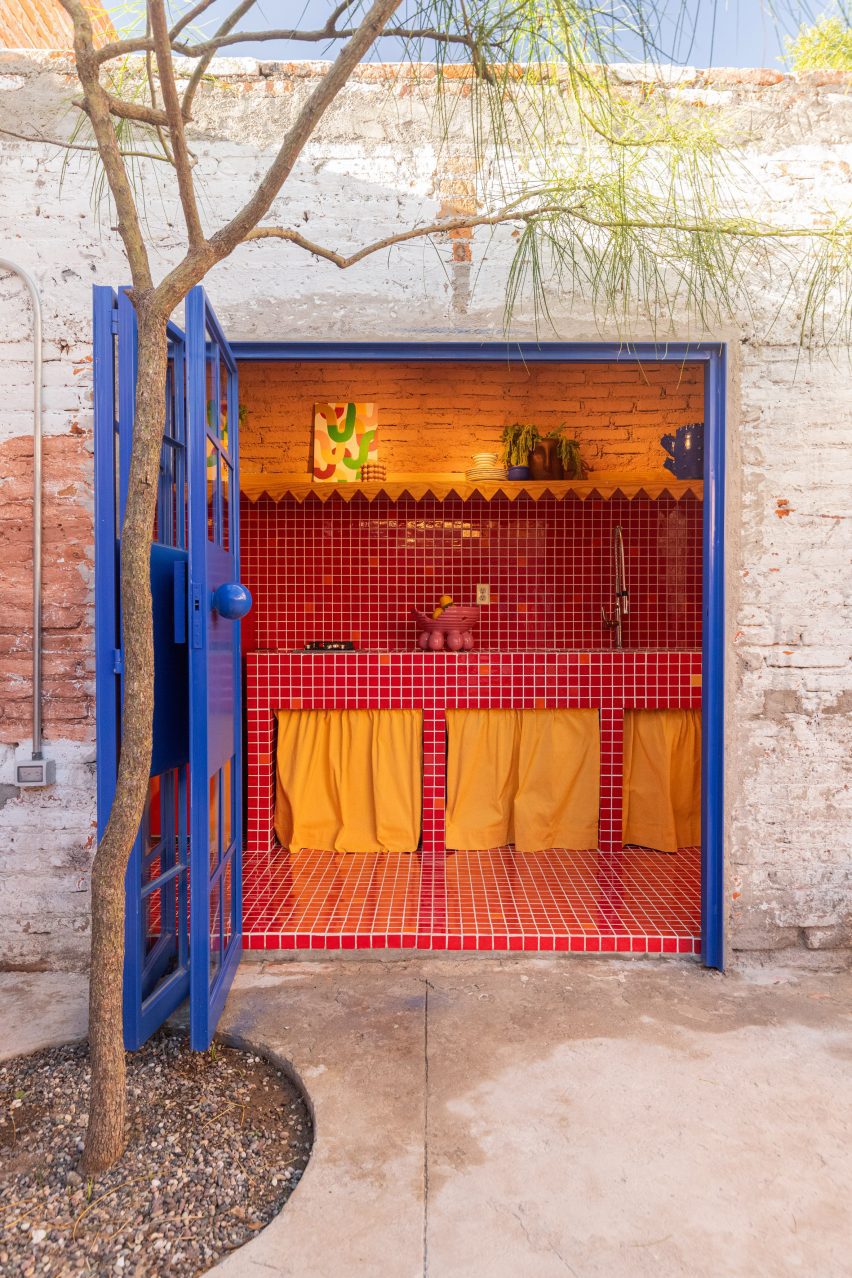 A blue door open to red-tiled kitchen