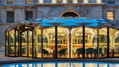 Café pavilion with silver roof reflected onto pond
