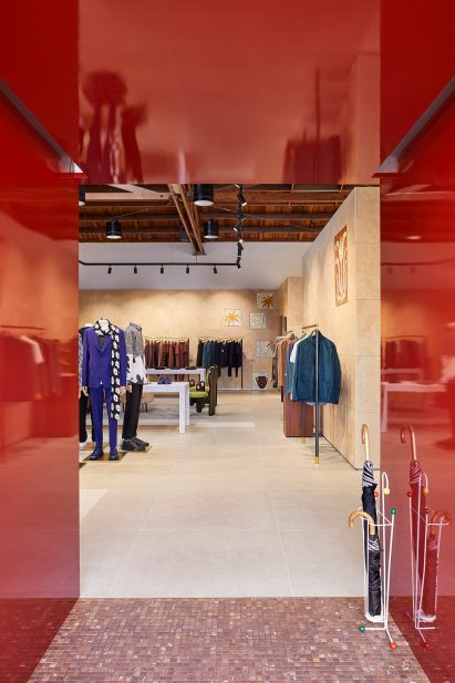 Glossy red metal vestibule with store interior beyond
