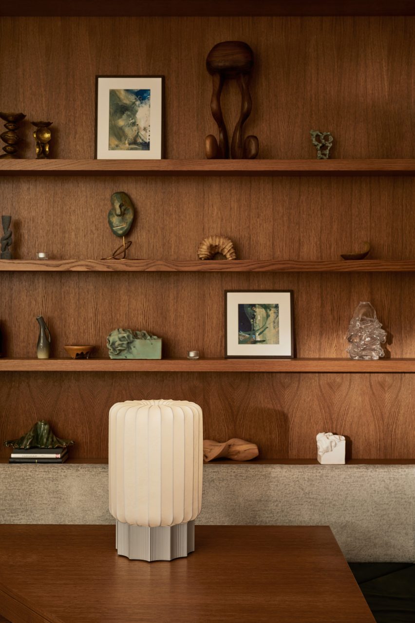 Off-white lamp in front of dark wood shelving