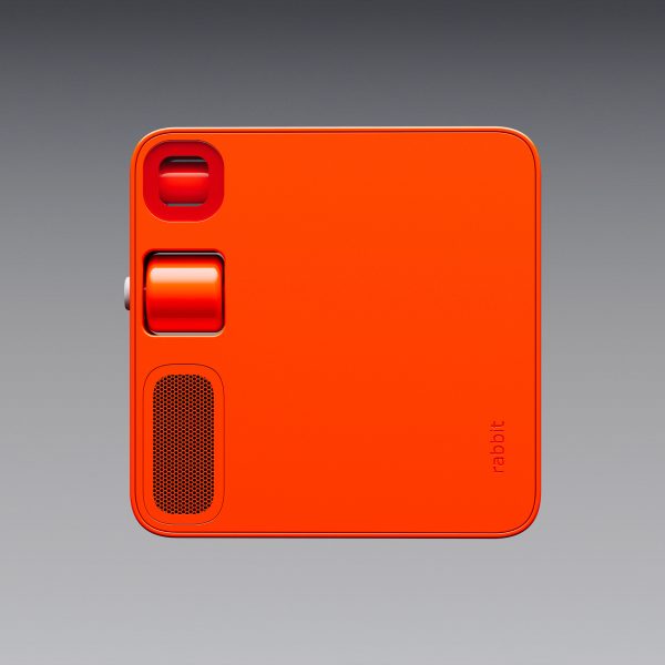 Image of the back the Rabbit R1 device, showing a closed camera lens, scroll wheel and speaker grille