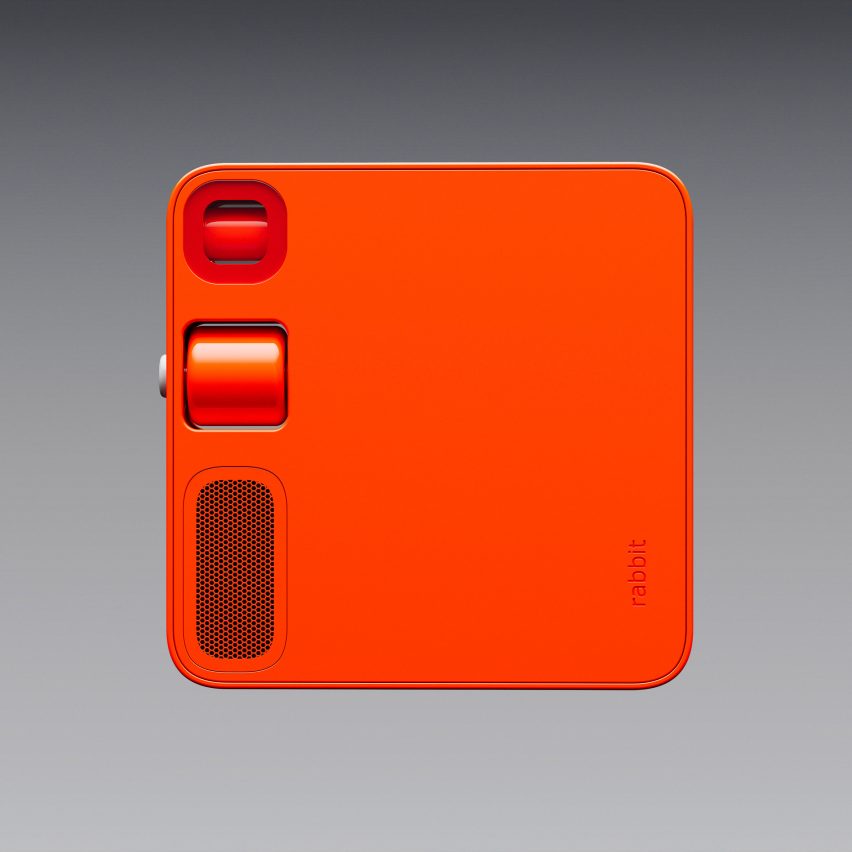 Image of the back the Rabbit R1 device, showing a closed camera lens, scroll wheel and speaker grille