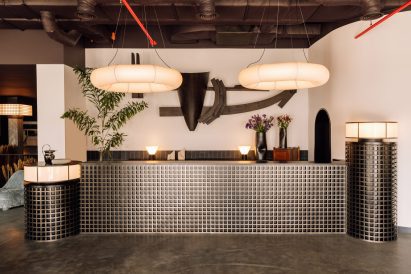 Reception desk with metal lattice front and hoop-shaped lights above