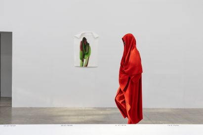 Model wearing all-red outfit from Issey Miyake Homme Plissé AW24 collection