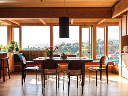 Dining room with large windows that have a view of hills in the distance