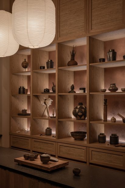 Objects displayed in wooden shelf inside wellness centre in Kyiv by Olga Fradina