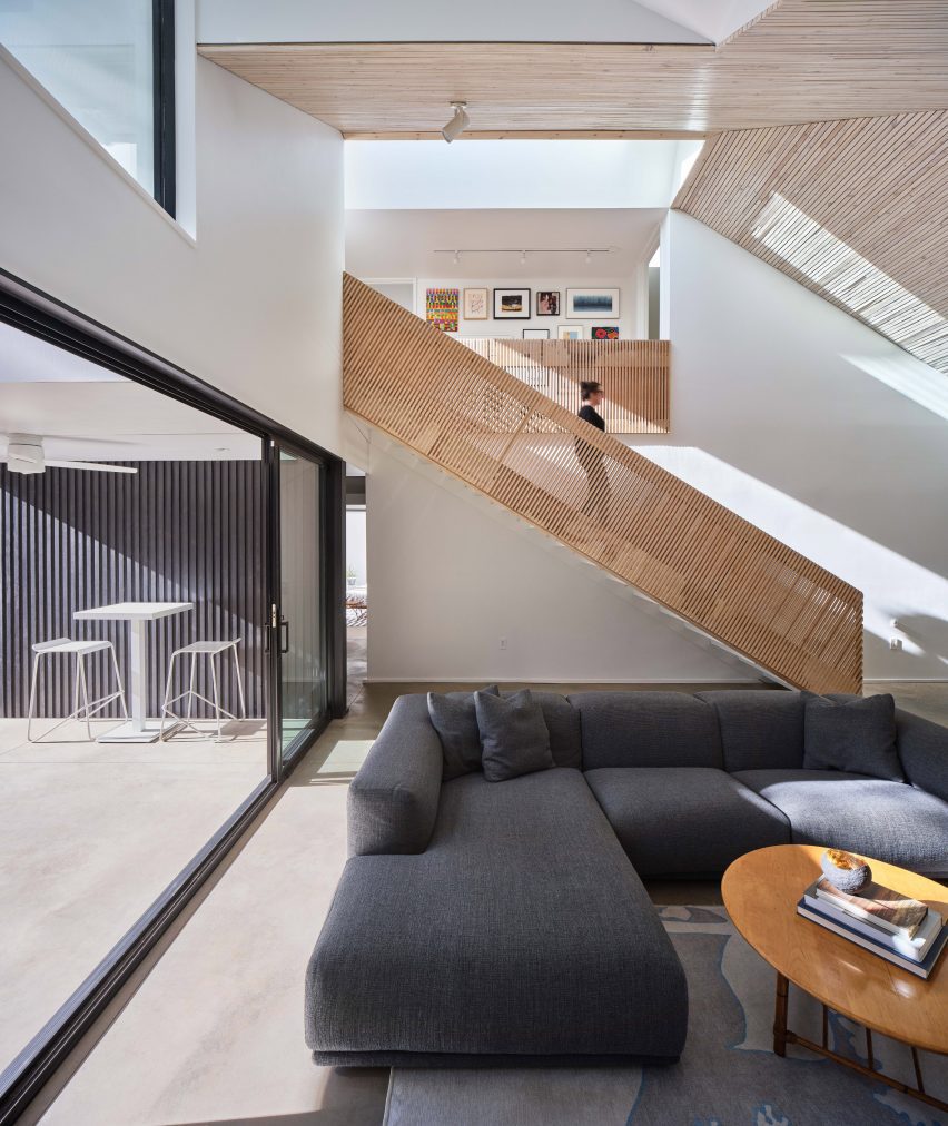 Living room with gray couch and wooden railing
