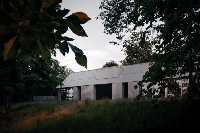 Cedar clad home through the trees