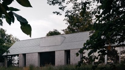 Grey cedar home with trees in foregroud
