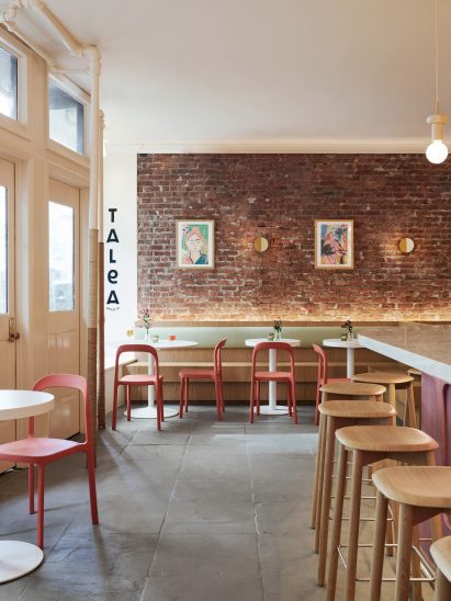 View towards an exposed brick wall with seating in front
