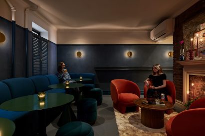 Dimly lit room with dark walls and colourful furniture