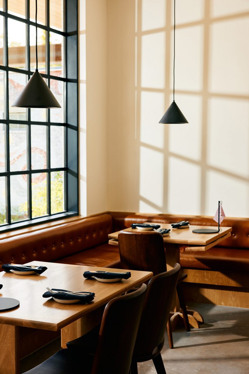 Wooden tables in front of a black framed window