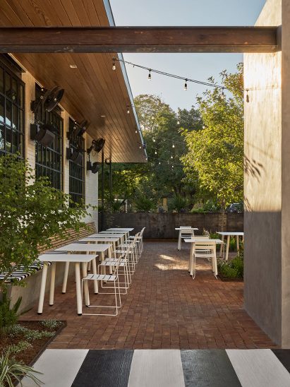 A patio with white metal seating and plants