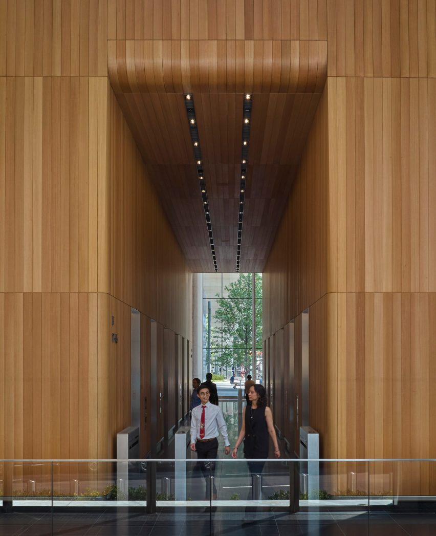 A tall wooden hallway in a skyscraper lobby