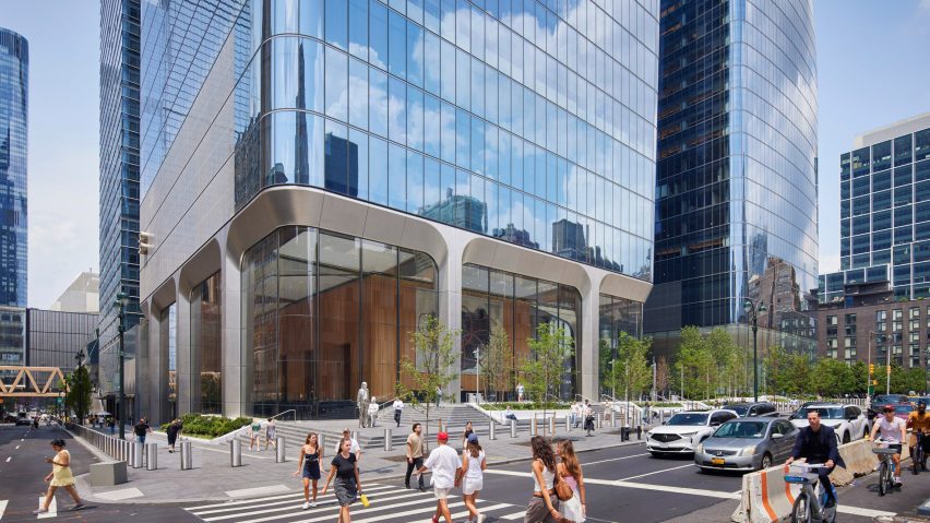People walking by large structural columns of a building