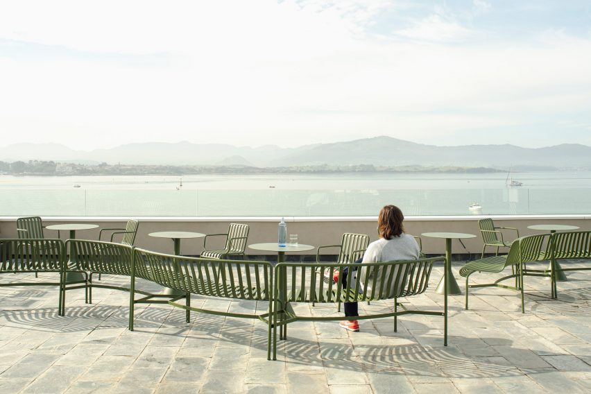 Terrace of brutalist restaurant in Spain by Zooco Estudio with green outdoor furniture