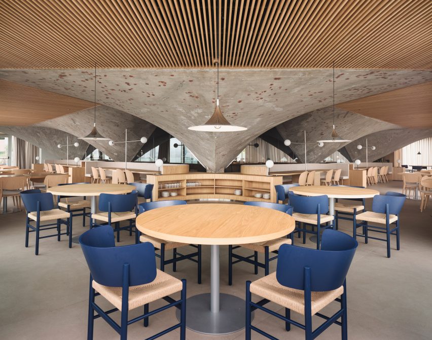 Timber ceiling panels and concrete paraboloids inside a brutalist restaurant in Spain by Zooco Estudio