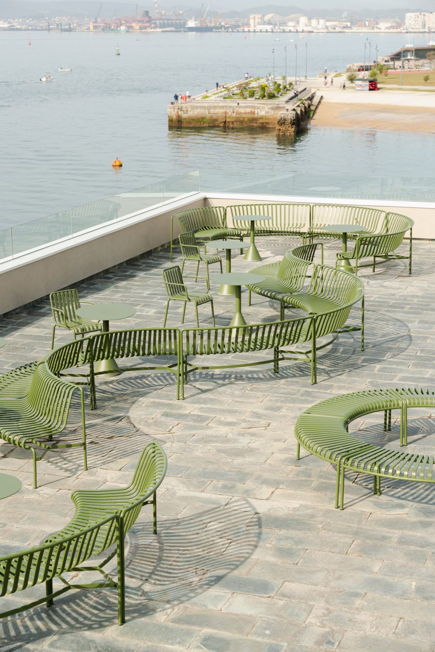 Terrace of brutalist restaurant in Spain by Zooco Estudio with green outdoor furniture