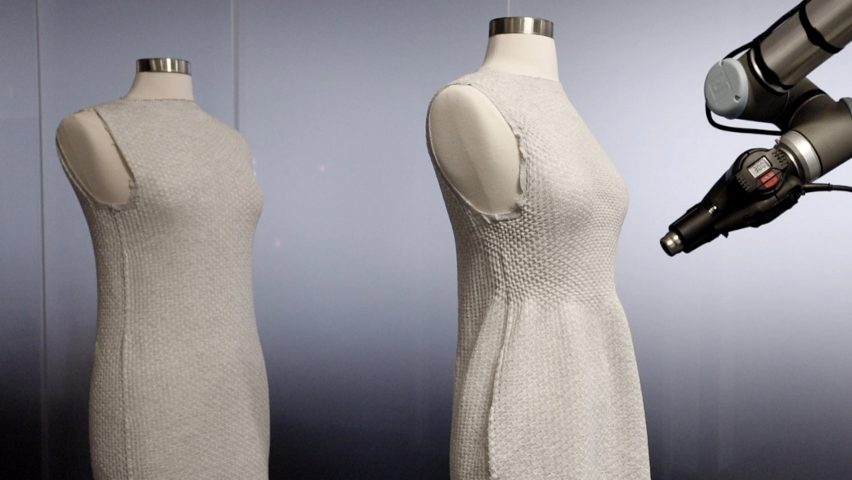 Still image of a white knit dress being formed to fit over a mannequin by a nearby robot arm hovering near it