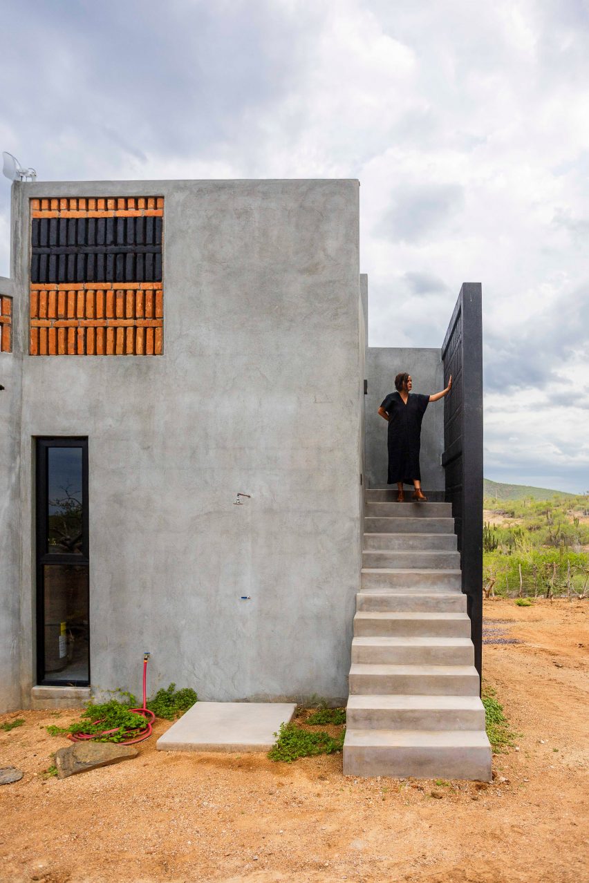 Concrete home with person standing on stairs