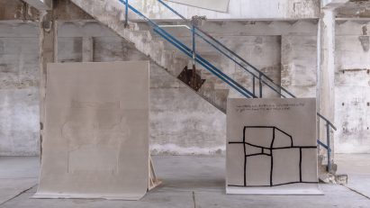 Rugs hanging in warehouse-like space