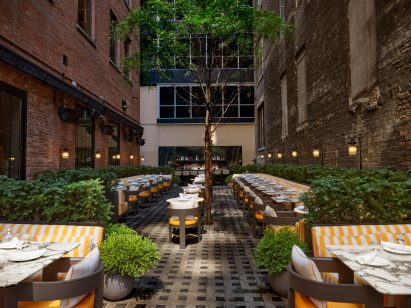 Outdoor dining area between two brick buildings
