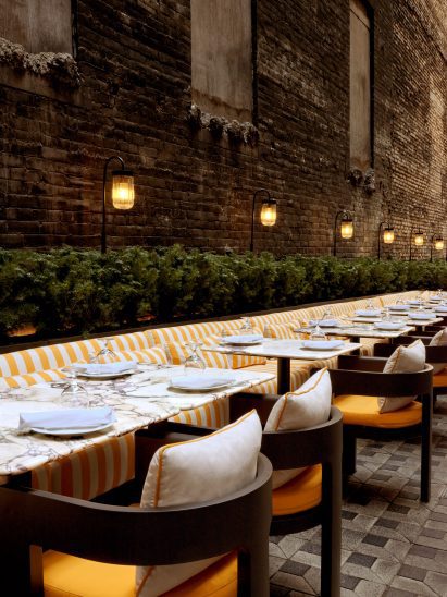 Yellow and white-striped seating running along a brick wal