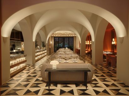 Neutral-toned dining room with dramatic vaulted ceilings and a checkered floor